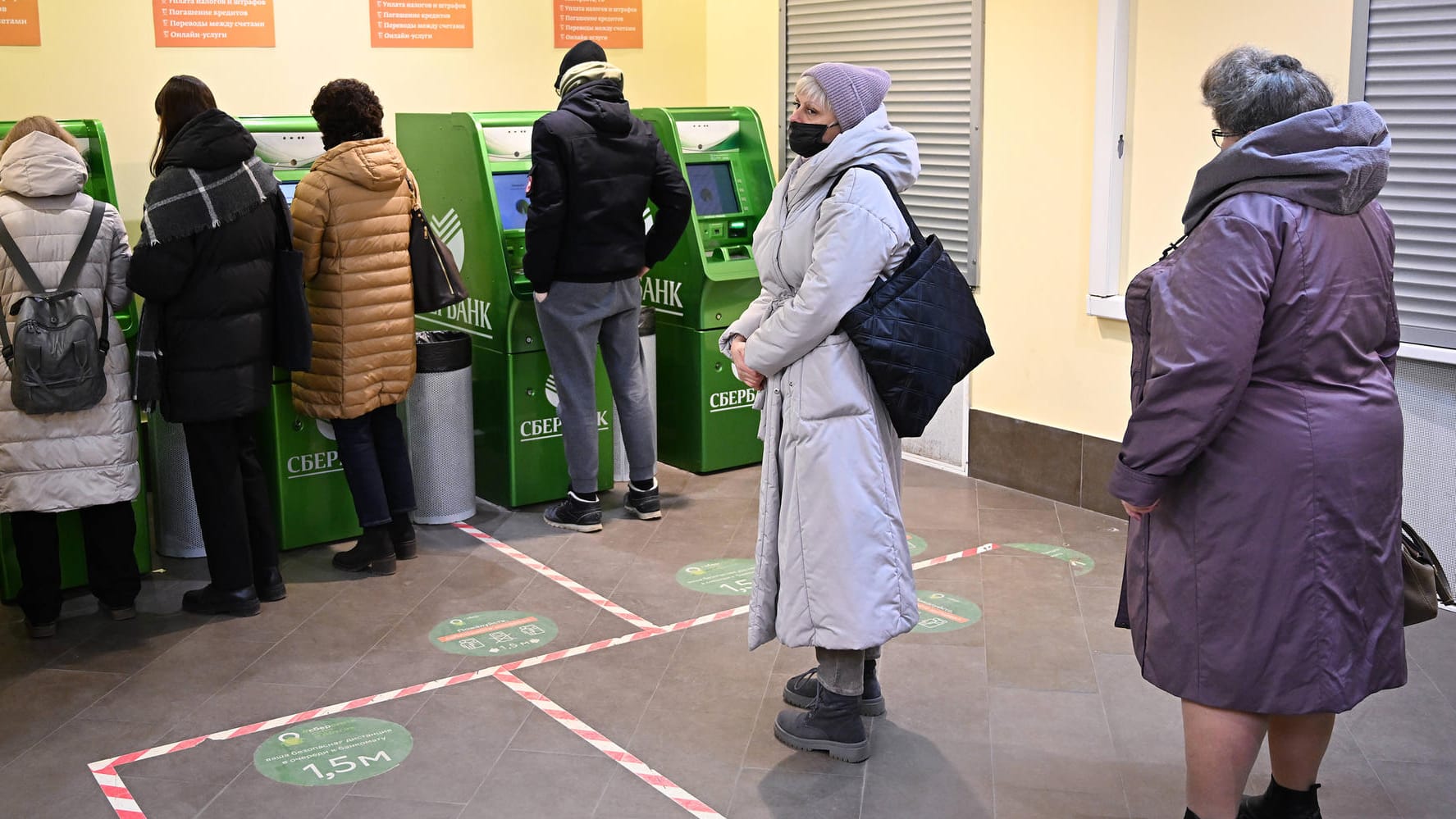 Menschen warten vor einem Bankautomat in Moskau (Symbolbild): Die westlichen Sanktionen treffen Russland schwer. Menschen warten vor einem Bankautomat in Moskau (Symbolbild): Die westlichen Sanktionen treffen Russland schwer.