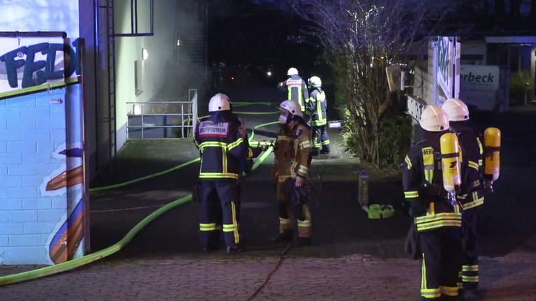 Einsatzkräfte der Feuerwehr stehen am Tropenhaus: Die Brandursache im Kölner Zoo wird ermittelt.