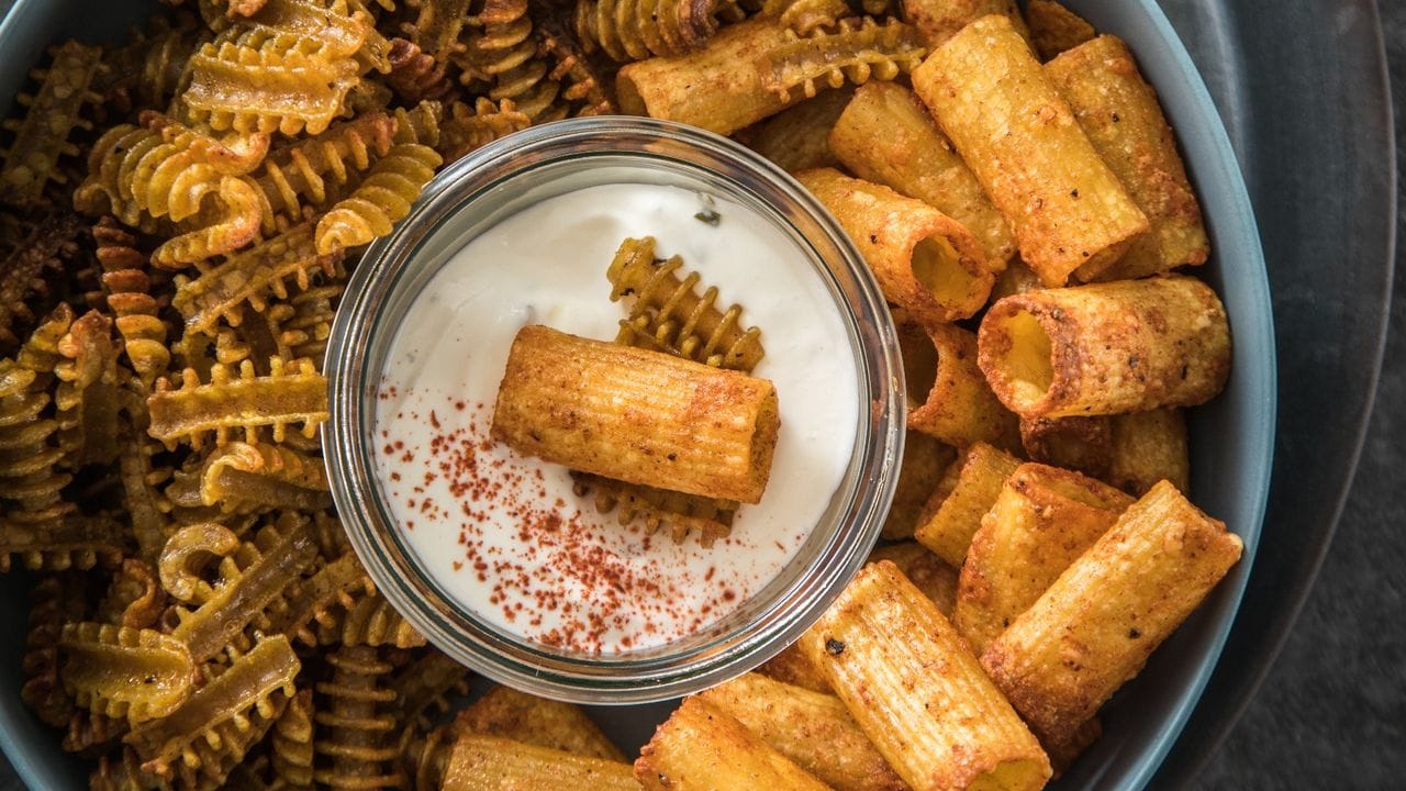 Gekochte Weizen-Rigatoni und Vollkorn-Radiatori werden in der Heißluftfritteuse zu knusprigen Pasta-Chips. Gekochte Weizen-Rigatoni und Vollkorn-Radiatori werden in der Heißluftfritteuse zu knusprigen Pasta-Chips.