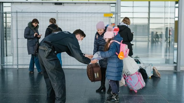 Ein Polizist verteilt im niedersächsischen Laatzen Schokolade an ein aus der Ukraine geflüchtetes Mädchen.