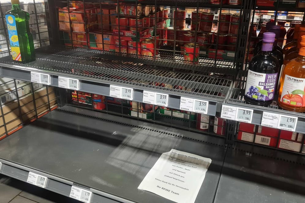 Ausverkauftes Regal in einem Kölner Supermarkt: Ein Schild weist Kunden auf die Mitnahmebegrenzung für Speiseöl, Zucker und Mehl hin.