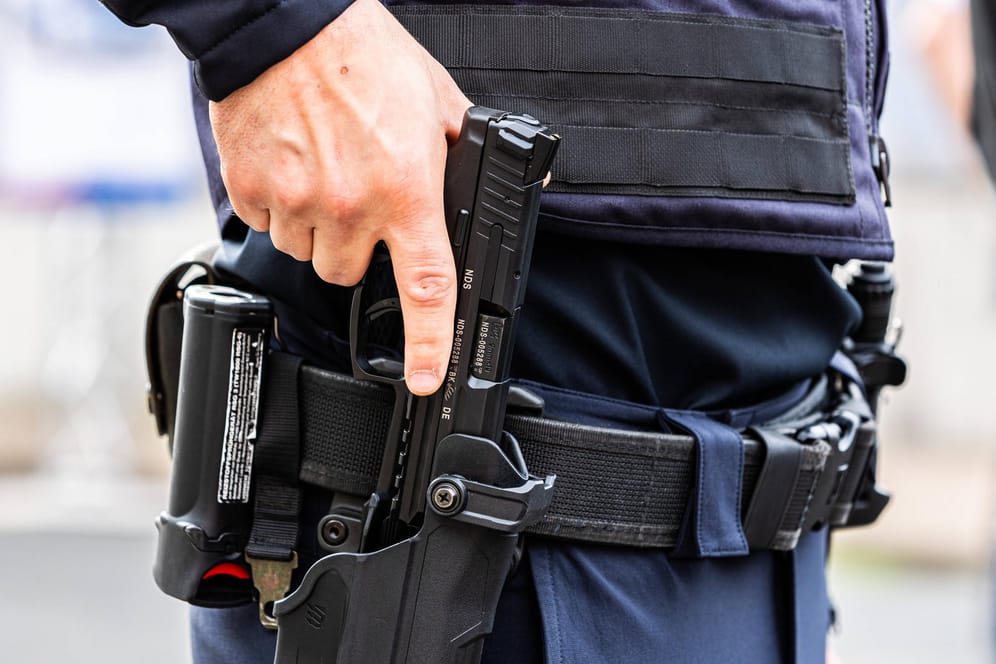 Ein Polizist hält die Hand an seiner Waffe (Symbolbild): Mit dem Schuss sollte der Senior "angriffsunfähig" gemacht werden.