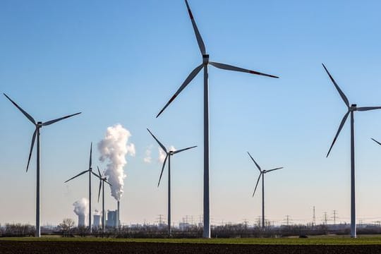 Braunkohlekraftwerk hinter Windrädern