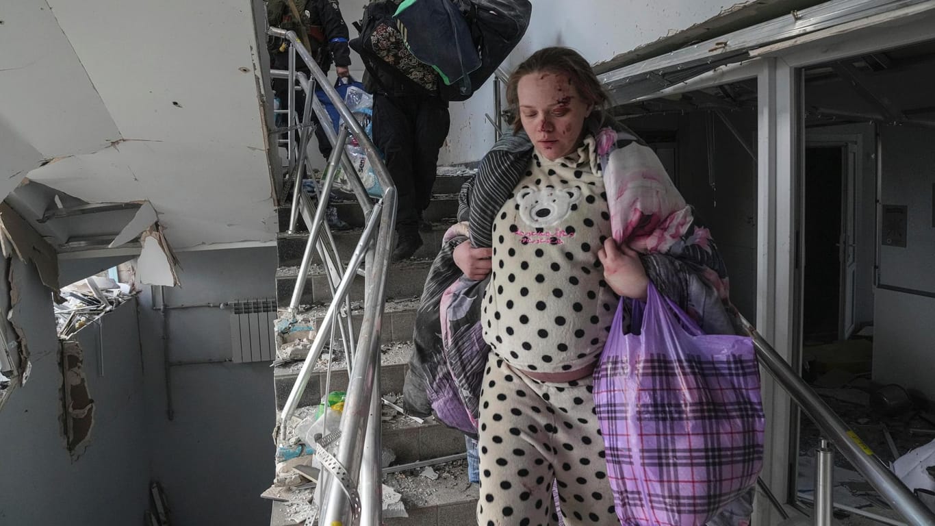 Eine verletzte schwangere Frau geht die Treppe eines Entbindungskrankenhauses in Mariupol hinunter: Russland behauptet nach seinem Angriff, das Gebäude sei von ukrainischen Kämpfern besetzt gewesen.