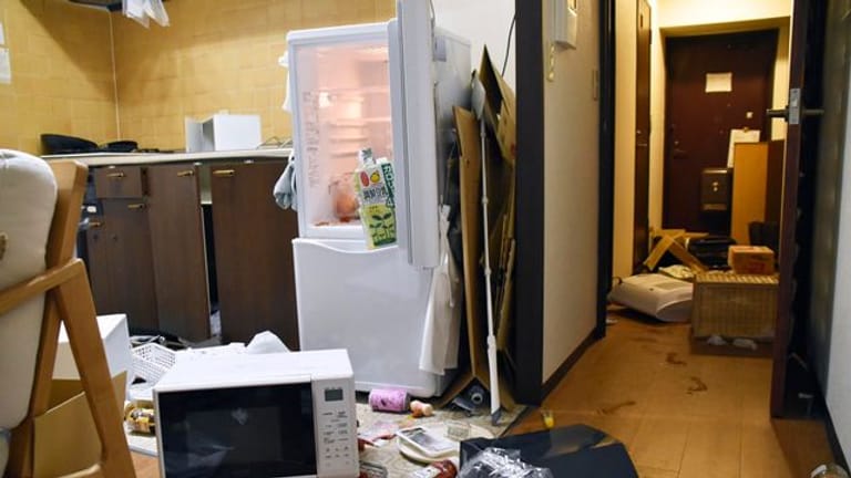 Möbel und Elektrogeräte liegen nach dem Erdbeben verstreut in einer Wohnung in Fukushima.