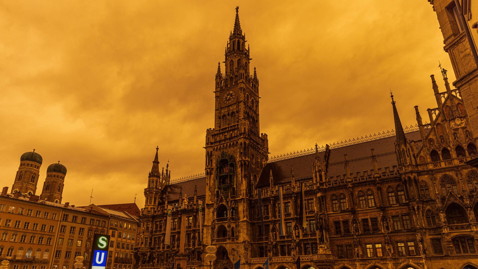 Der Marienplatz in München vor rotem Himmel: Saharastaub färbt die Luft und Oberflächen in der Stadt in seltenem Licht.