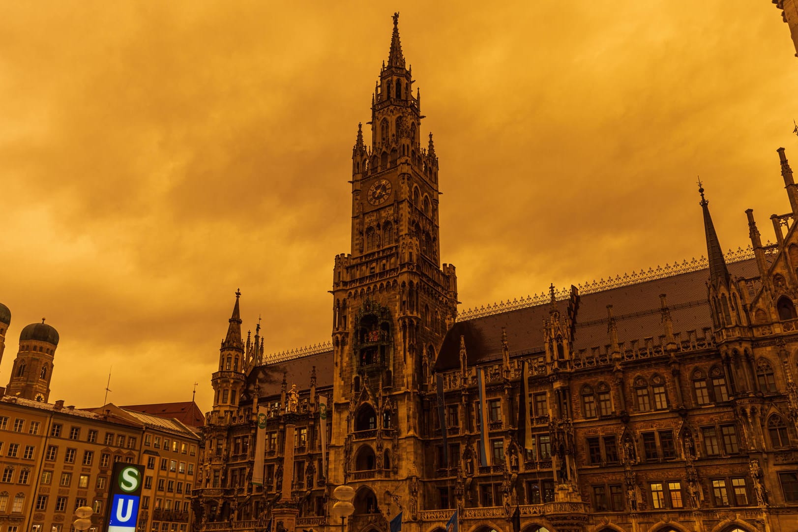 Der Marienplatz in München vor rotem Himmel: Saharastaub färbt die Luft und Oberflächen in der Stadt in seltenem Licht.