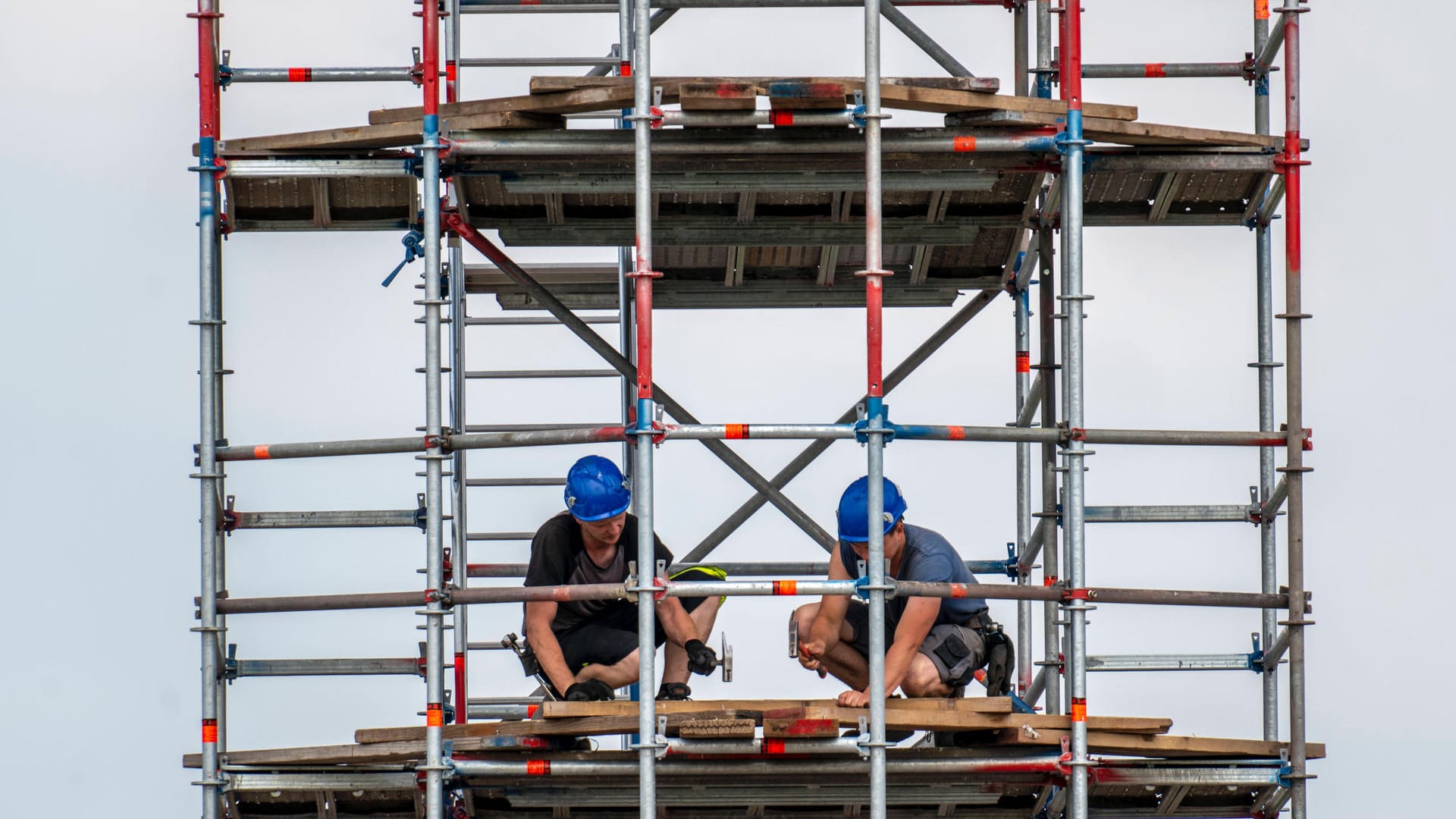 Arbeiter auf einem Baugerüst auf einer Baustelle in Deutschland (Symboldbild): Bei einer Razzia in mehreren Städten wurde ein Schwarzgeldnetzwerk unter Bauunternehmern entlarvt. Arbeiter auf einem Baugerüst auf einer Baustelle in Deutschland (Symboldbild): Bei einer Razzia in mehreren Städten wurde ein Schwarzgeldnetzwerk unter Bauunternehmern entlarvt.