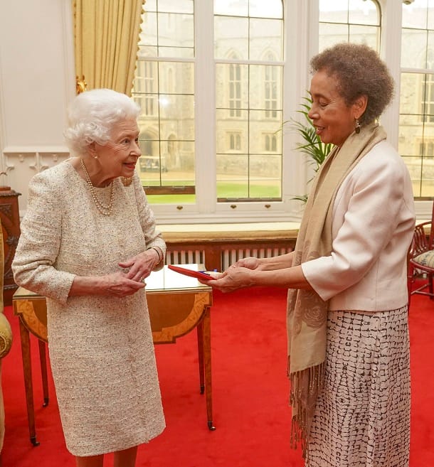 Die Queen überreicht Grace Nichols eine goldene Medaille.