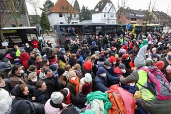 Menschen, die aus der Ukraine geflohen sind, warten vor dem Amt für Migration in Hamburg: Mit der Online-Terminvergabe sollen lange Warteschlangen verhindert werden.