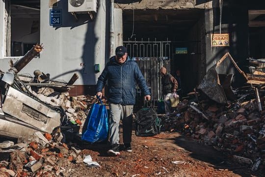 Kaum noch was übrig: Ein Mann trägt seine Habseligkeiten aus seinem zerstörten Haus in Charkow.