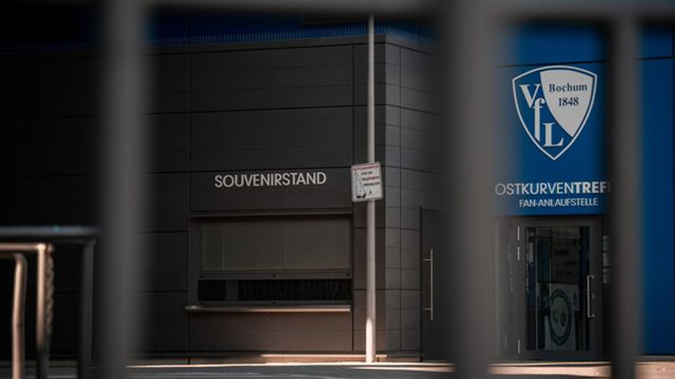 Ein Schild mit dem Logo des VfL Bochum hängt am Stadion neben dem Souvenirstand.