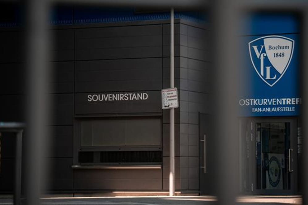 Ein Schild mit dem Logo des VfL Bochum hängt am Stadion neben dem Souvenirstand.