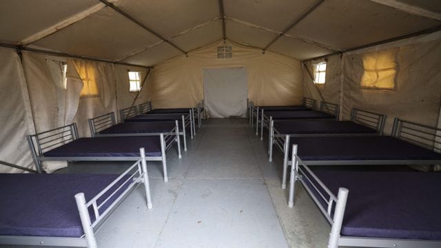 Ein Zelt für ukrainische Flüchtlinge wird mit Betten ausgestattet und weiter vorbereitet: In den Messehallen stehen zudem 2.000 Schlafplätze zur Verfügung.