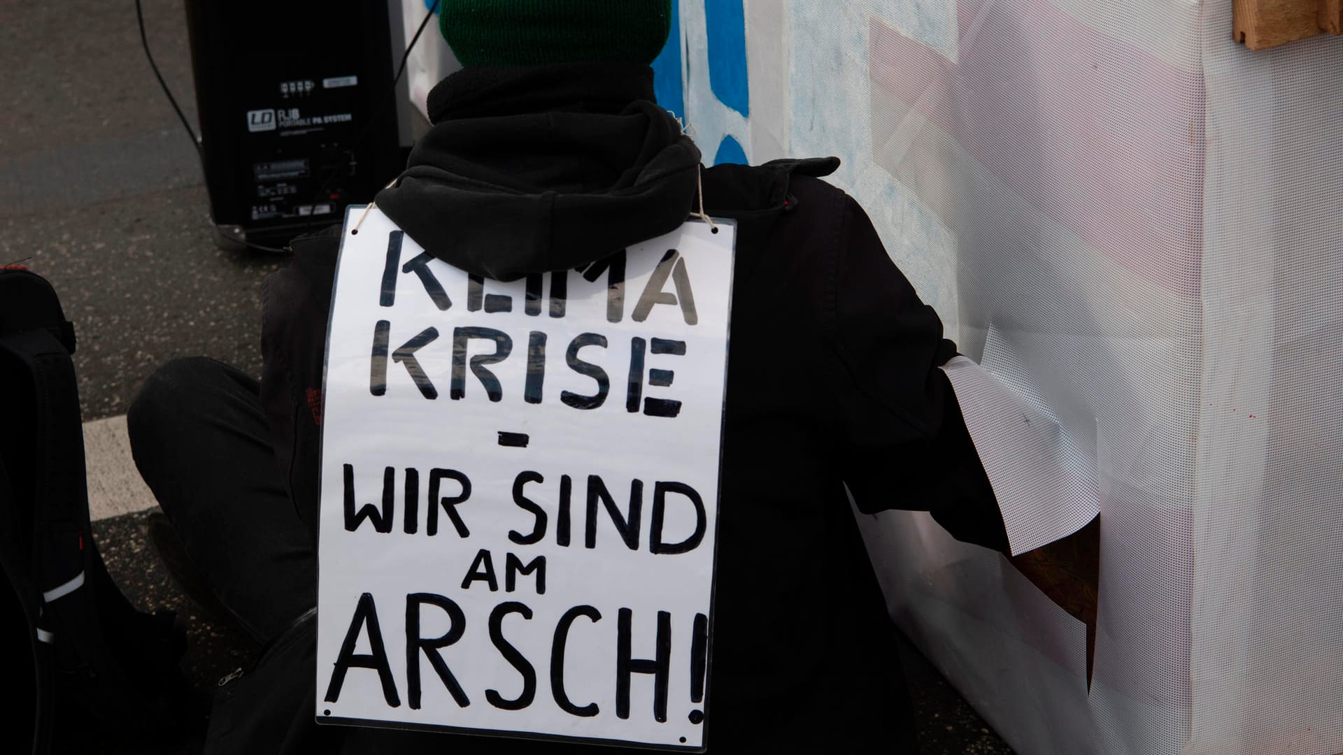 "Klimakrise - wir sind am Arsch" steht auf dem Plakat eines Anhängers einer Klimaschutzbewegung bei einer Sitzblockade auf der Marschall-Brücke Anfang März. (Symbolbild): Am Wochenende soll es wieder zu zahlreichen Sperrungen in der Hauptstadt kommen.