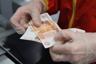 Kassierer hält Rubel-Banknote in der Hand (Symbolbild): Die russische Währung verlor in den vergangenen Wochen drastisch an Wert.