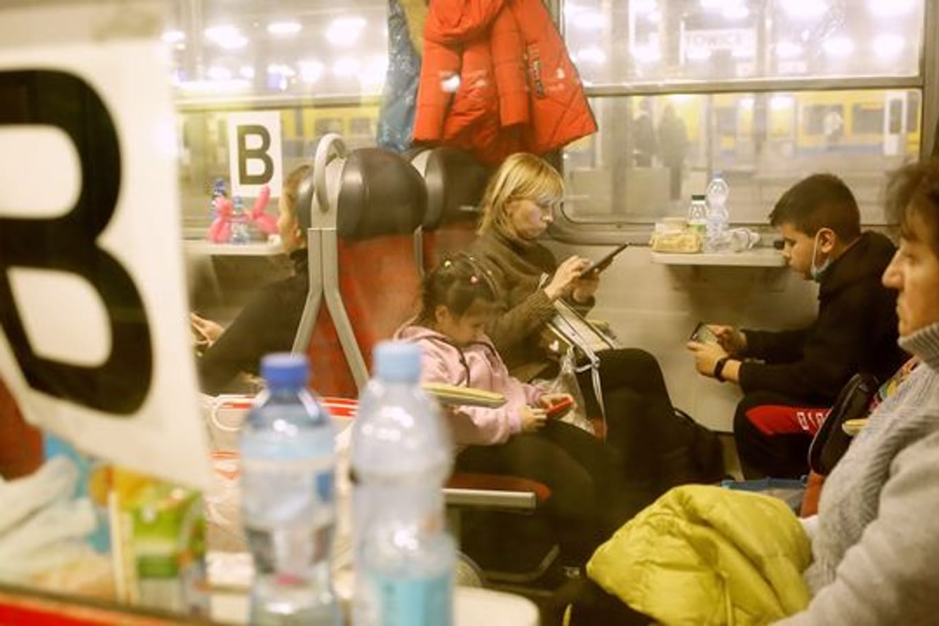 Flüchtlinge aus der Ukraine sitzen am Bahnhof in einem Personenzug in Richtung Deutschland.