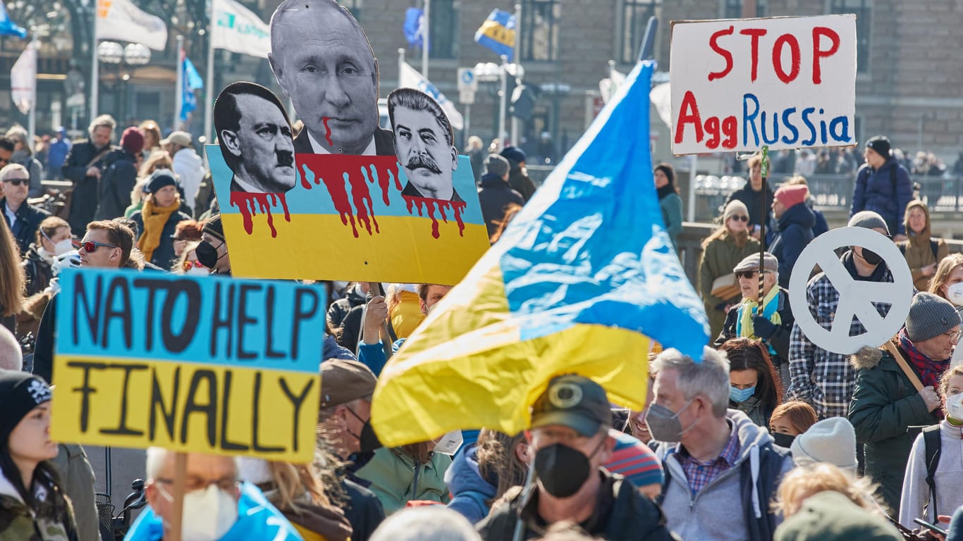 Teilnehmende der Demonstration "Frieden in der Ukraine – Sicherheit in Europa" halten auf dem Jungfernstieg Transparente: In Hamburg sollen mehrere tausend Menschen auf den Straßen unterwegs sein.