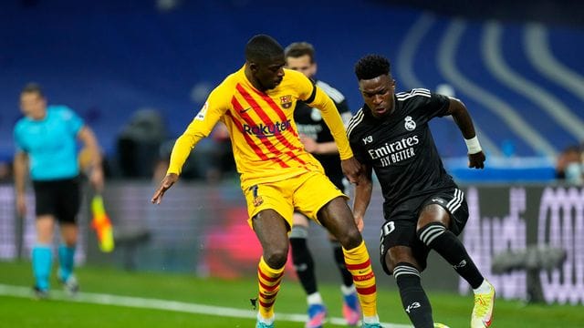 Ousmane Dembélé (l) vom FC Barcelona im Duell mit Real-Profi Vinicius Junior.