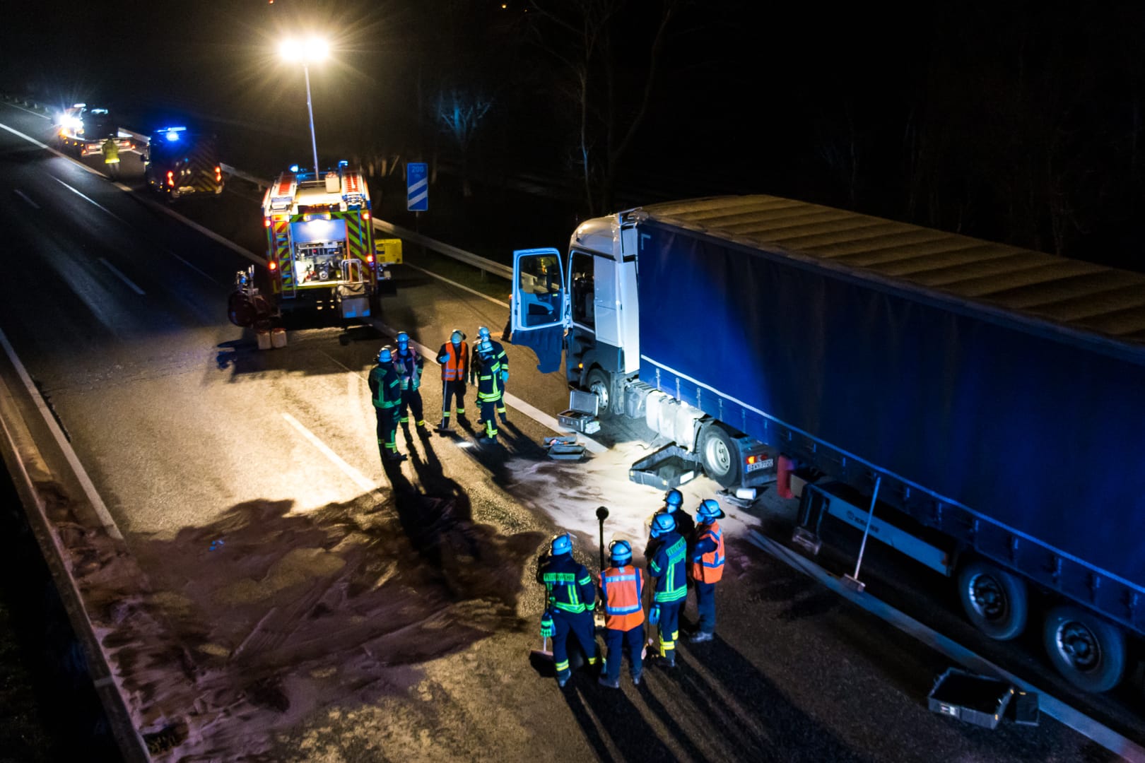 Einsatzkräfte am Lkw: Bei dem Unfall sind große Mengen Diesel auf die Fahrbahn ausgelaufen.