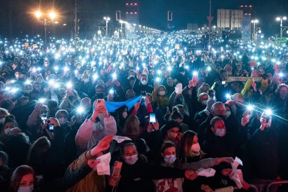 Zahlreiche Zuschauer leuchten mit ihren Handy-Taschenlampen bei "Sound of Peace" am Brandenburger Tor.