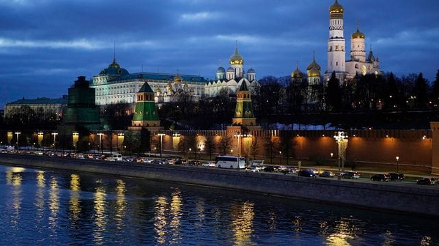 Autos fahren am Ufer der Moskwa vor dem Kreml vorbei.