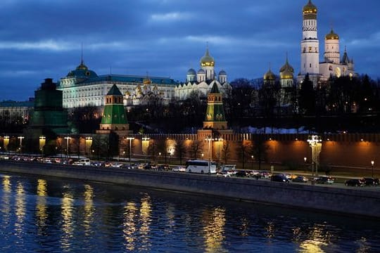 Autos fahren am Ufer der Moskwa vor dem Kreml vorbei.