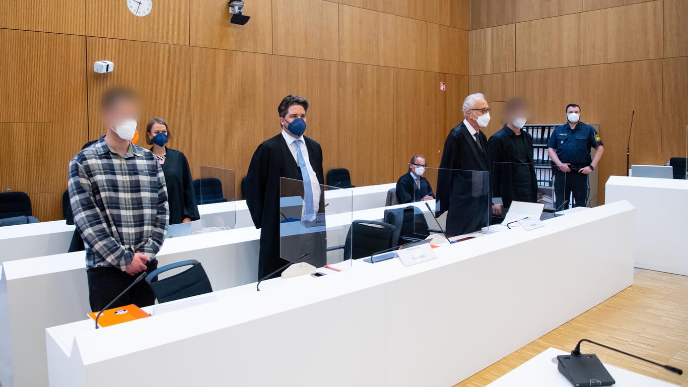 München: Die zwei wegen Mordes angeklagten Männer (l und 2.v.r.) stehen vor Beginn der Verhandlung mit ihren Anwälten im Sitzungssaal (Archivbild): Der Hauptangeklagte hat nun überraschend ein Geständnis abgelegt.