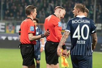 Spielabbruch: Nachdem Schiedsrichter Assistent Christian Gittelmann (M.) während der Partie Bochum gegen Gladbach von einem Becher am Kopf getroffen wurde, ging es auf dem Rasen nicht mehr weiter.