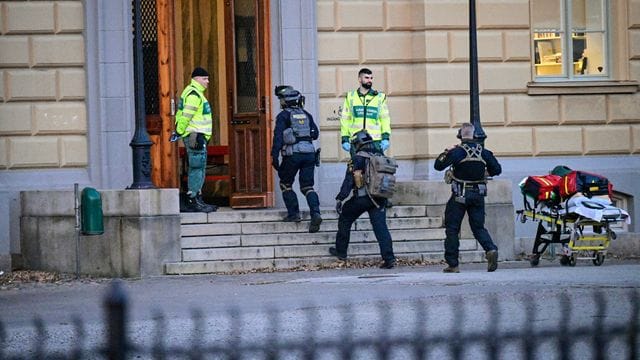 Polizisten betreten den Tatort an einer Schule.