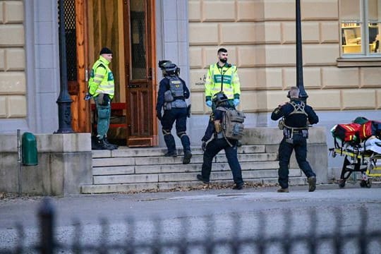 Polizisten betreten den Tatort an einer Schule.