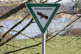 Schild mit der Aufschrift Naturschutzgebiet vor einem See (Symbolbild): Der Landkreis Harburg hat künstliche Brutplätze auf schwimmenden Inseln geschaffen.