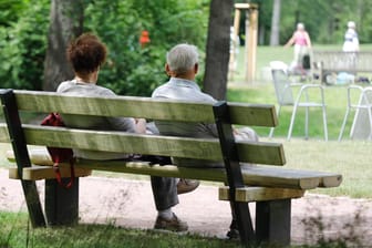 Rentnerpaar auf einer Bank (Symbolbild): Die Rentenanpassung fällt in diesem Jahr höher aus als bislang erwartet.