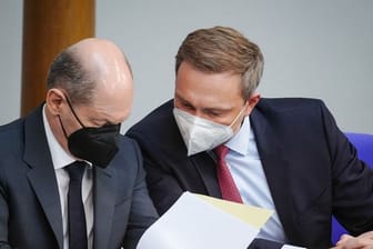 Finanzminister Christian Lindner (r, FDP) und Bundeskanzler Olaf Scholz (SPD) unterhalten sich im Bundestag.