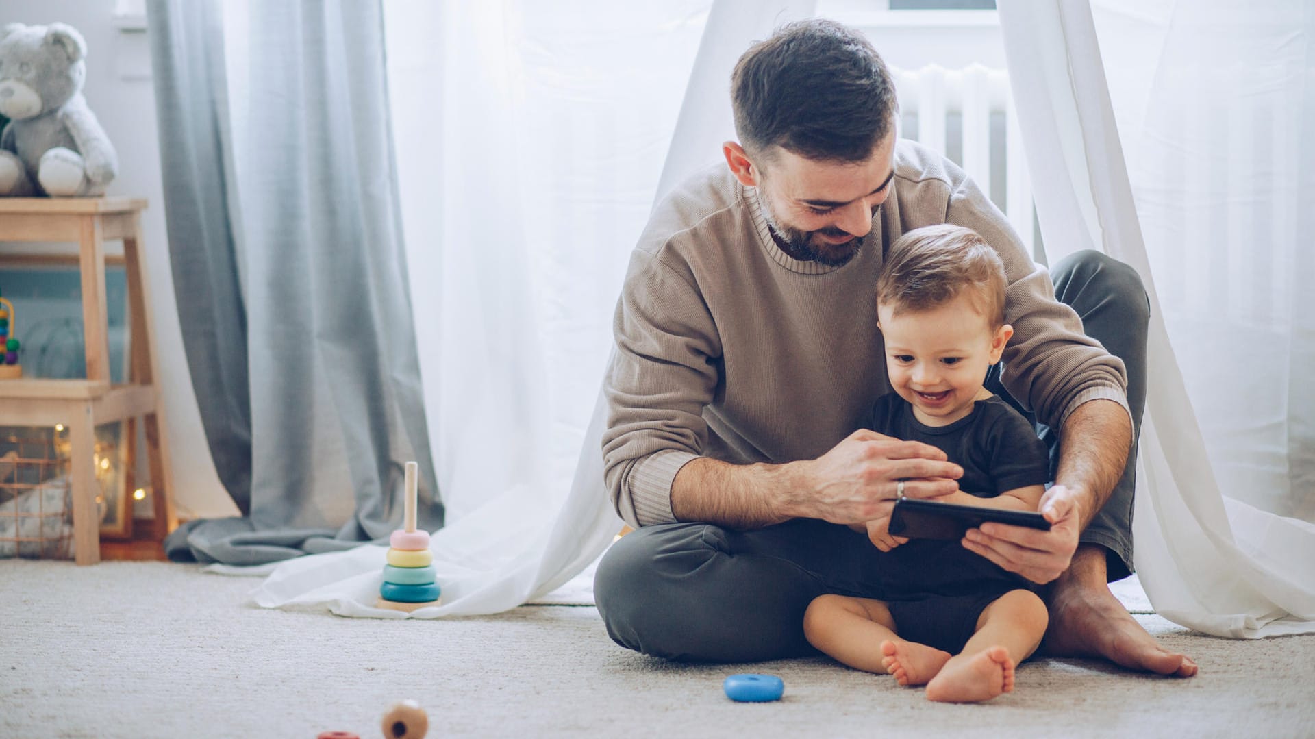 Vater und Sohn im Kinderzimmer (Symbolbild): Wer in Teilzeit arbeitet, kann häufiger mit der Familie zusammen sein.