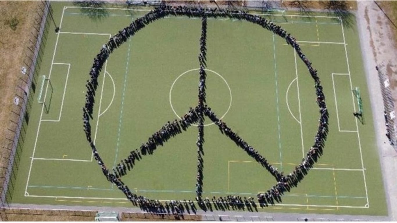 900 Schüler bilden das Friedenszeichen.