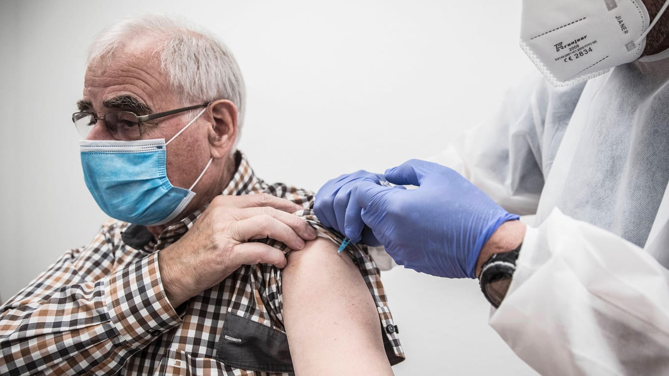 Ein Mann wird gegen Corona geimpft (Symbolbild): In Deutschland steigt die Inzidenz noch immer an.