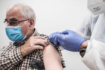 Ein Mann wird gegen Corona geimpft (Symbolbild): In Deutschland steigt die Inzidenz noch immer an.