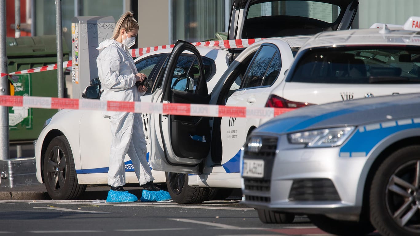 Eine Kriminaltechnikerin der Spurensicherung an einem Auto der Fahrschule: Hier stach der Angreifer auf mehrere Menschen ein.