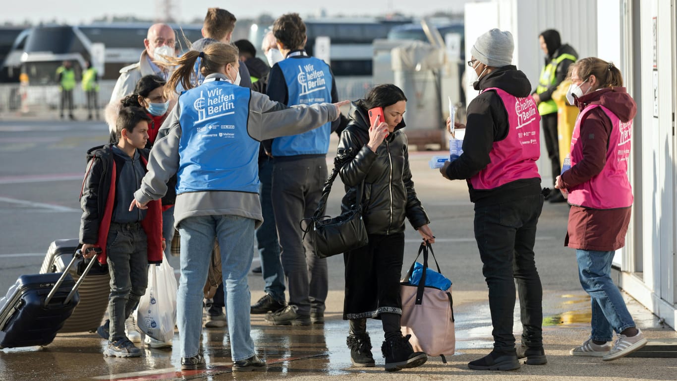 Mitarbeitende weisen Geflüchtete am Ankunftszentrum auf dem Flughafen Tegel ein (Archivbild): 420 Mitarbeiter braucht es allein für diesen Standort.