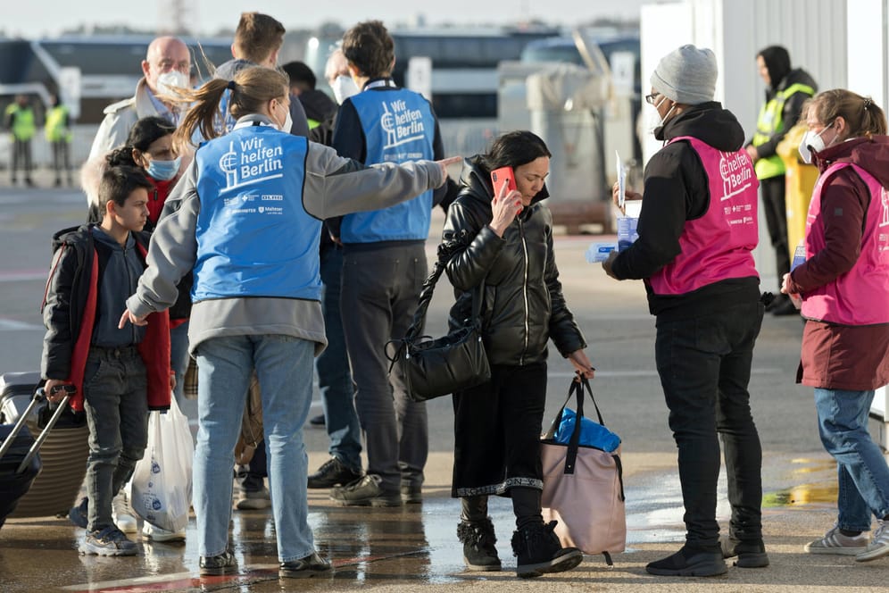 Mitarbeitende weisen Geflüchtete am Ankunftszentrum auf dem Flughafen Tegel ein (Archivbild): 420 Mitarbeiter braucht es allein für diesen Standort.