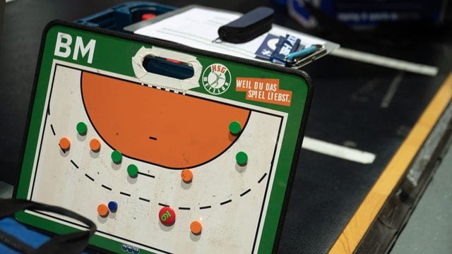 Ein Taktikbrett mit dem Logo der HSG Wetzlar ist in der Rittal Arena an der Seitenlinie zu sehen.