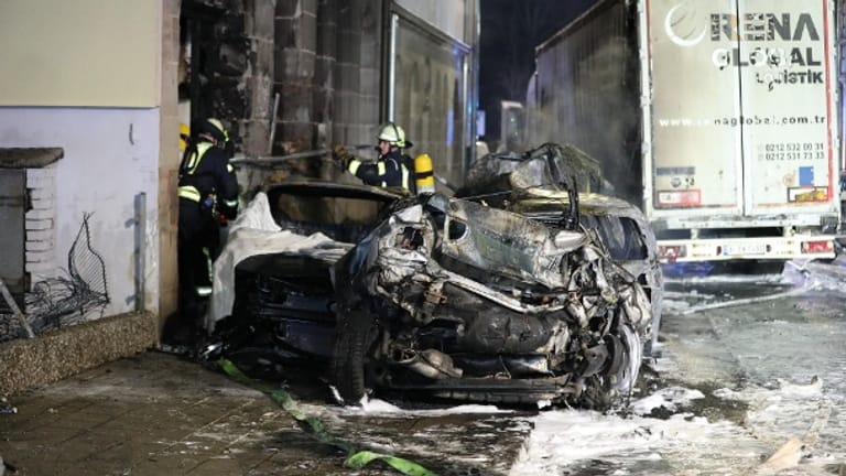 Ein ausgebrannter Wagen, im Hintergrund der Unfall-Lkw: Die Fürther Hardstraße glich nach der Chaosfahrt eines betrunkenen Lkw-Fahrers einem Ort der Zerstörung.