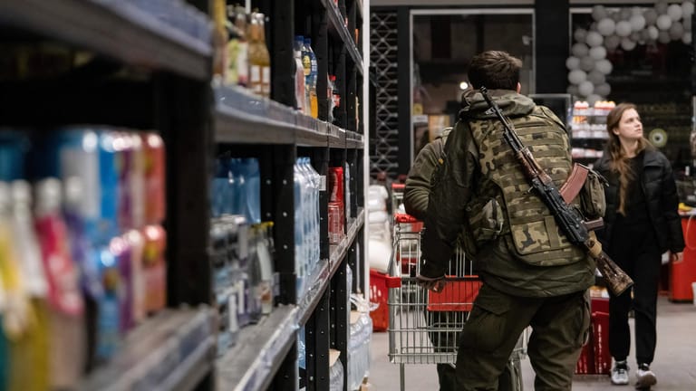 Ukrainischer Soldat in einem Supermarkt in Kiew: Die Behörden warnen die Bevölkerung vor Selbstjustiz.