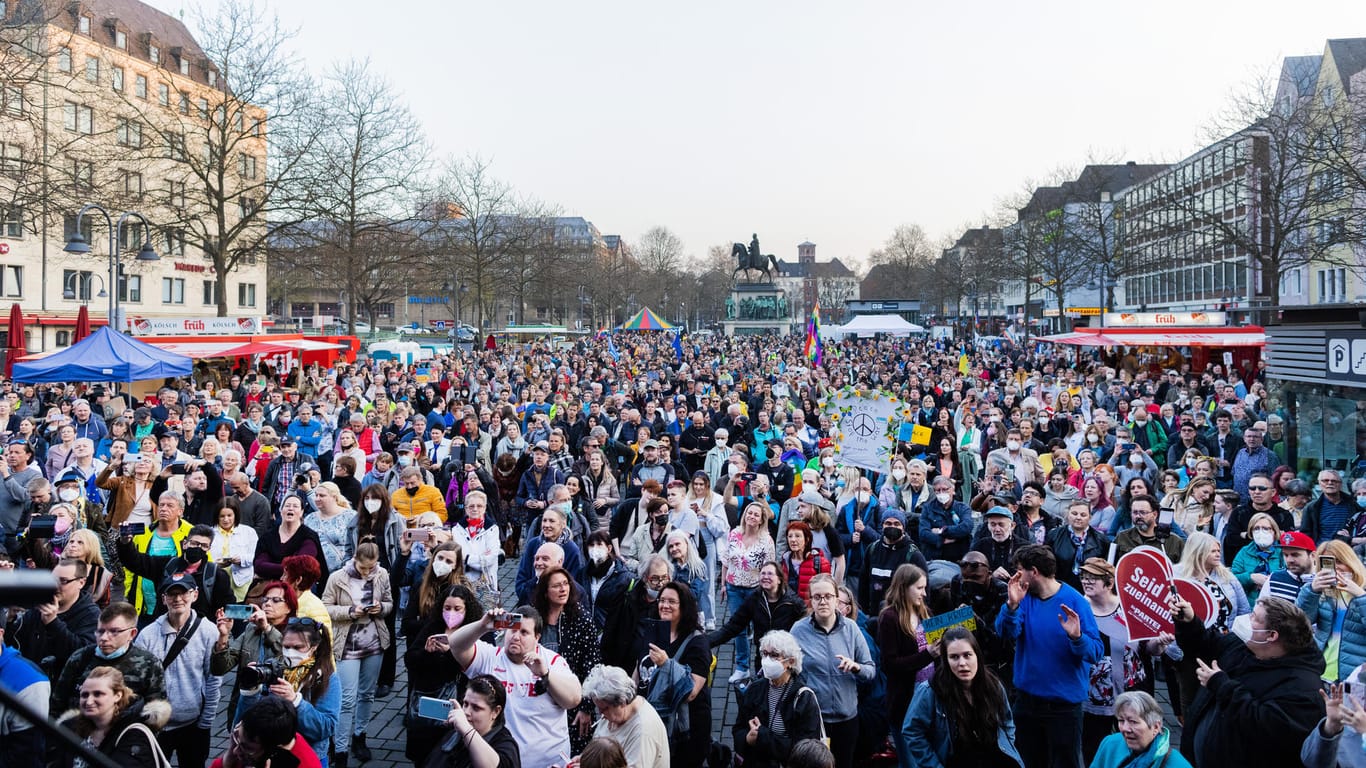 Solidarität für die Ukraine in Köln: Hunderte Menschen stehen bei einer Friedenskundgebung mit Benefizkonzert für die Ukraine unter dem Titel "Peace Please" auf dem Heumarkt.
