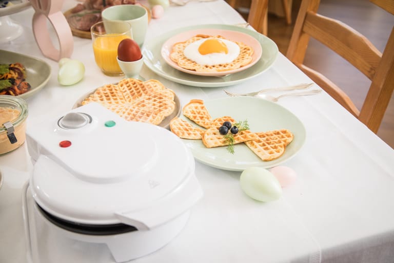 Mit Teig und Waffeleisen auf dem Tisch können die Gäste vom Osterbrunch selbst Hand anlegen. Die Waffeln können danach zu einem Waffel-Hasen dekoriert werden.