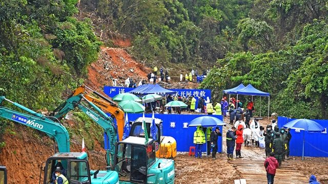Regen und aufgeweichte Böden erschweren die Suche der Rettungskräfte.