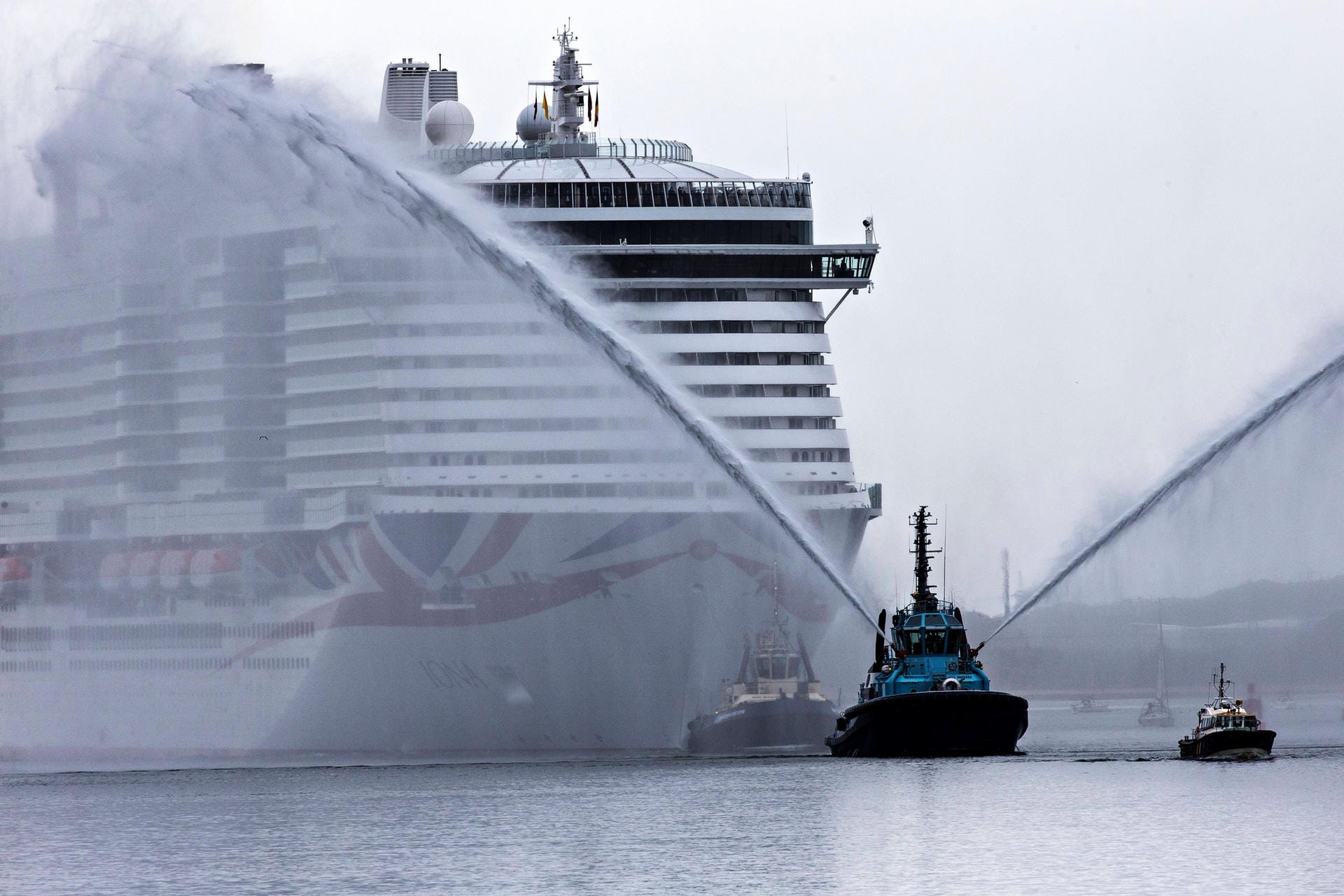 Wasserwerfer begleiten die MS Iona auf ihrem Weg in einen Hafen. Sie ist das größte bisher gebaute Kreuzfahrtschiff der Welt. 5.206 Passagiere finden Platz auf dem Luxus-Liner. Am 4. April ist das Schiff auch in Hamburg zu Gast.