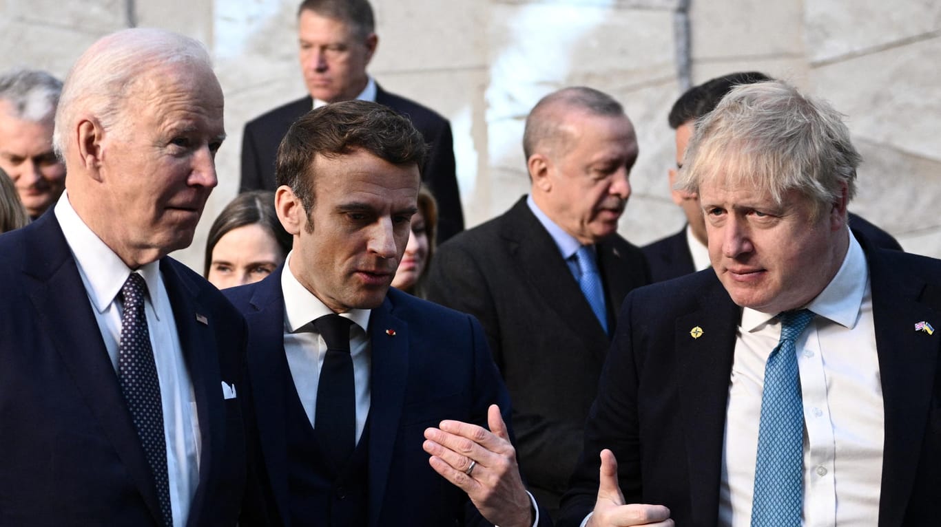 Boris Johnson (r) mit US-Präsident Joe Biden (l) und dem französischen Präsidenten Emmanuel Macron (m): Johnson will die Sanktionen gegen Russland verschärfen.