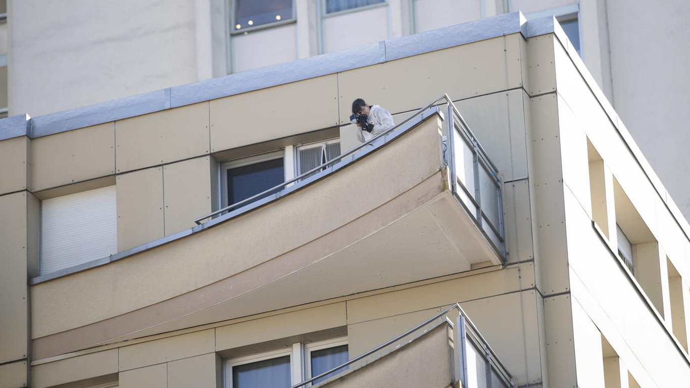 Ein Kriminalpolizist sichert Beweise: Von dem Balkon stürzten vier Mitglieder einer Familie in den Tod.